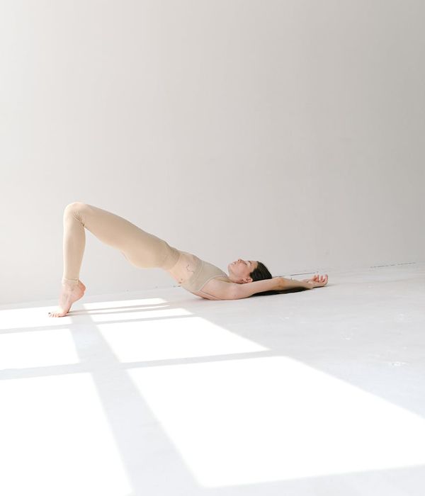 Woman in a calm yoga pose on a light background.